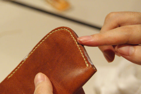 縫い終わったら、革の縁に光沢剤を塗って仕上げる。